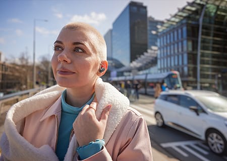 Moteris mėgaujasi lauke naudodama tikras belaides ausines &bdquo;Philips T3508