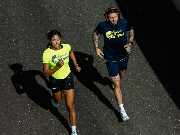 Du bėgikai lenktyniauja, kad liktų prie&scaron;ais fiksavimo automobilį.