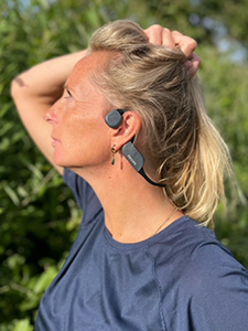 Moteris dėvi &bdquo;Philips&ldquo; kaulų laidumo &bdquo;Bluetooth&ldquo; ausines